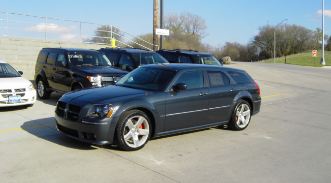 Blue Dodge Magnum SRT8 parked among other cars in the dealer lot